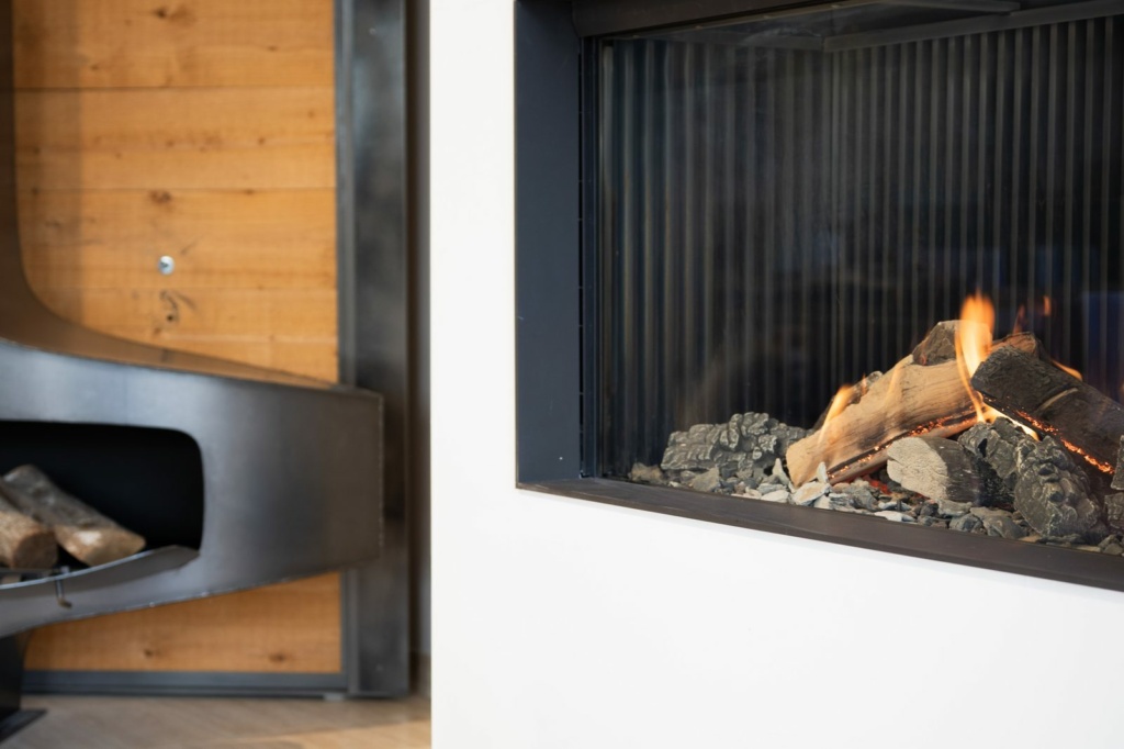 Foyer gaz allumé face à un mur en bois, showroom Sparte à Toulouse