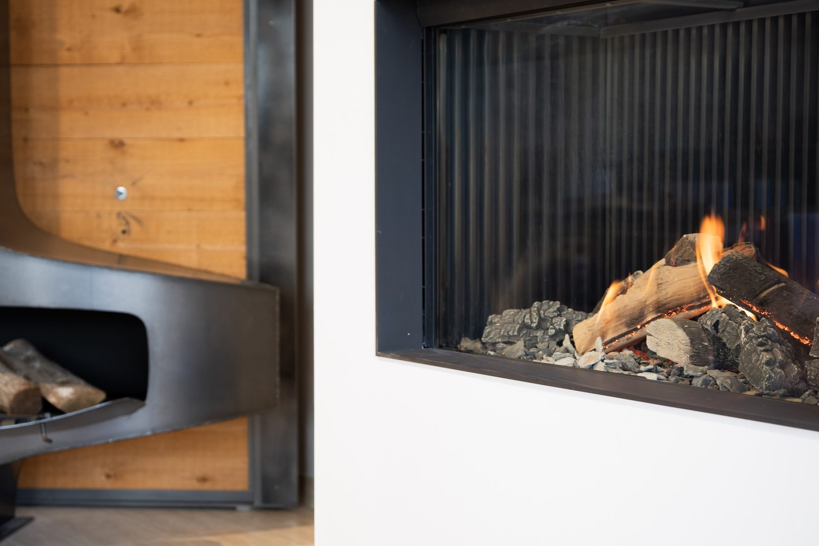 Foyer gaz allumé face à un mur en bois, showroom Sparte à Toulouse