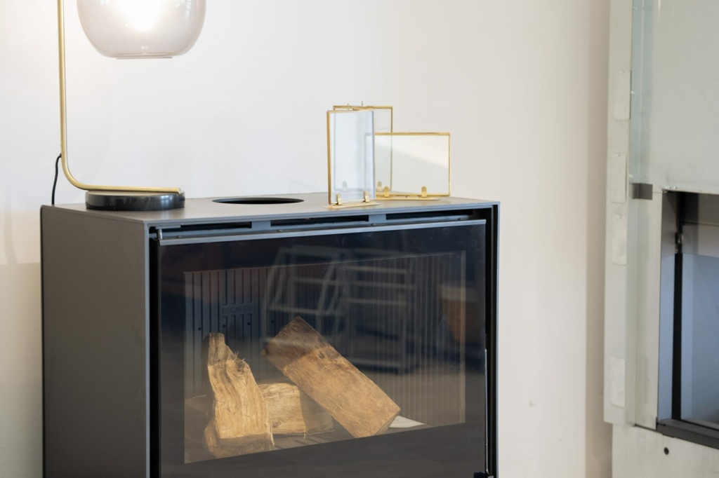 Foyer à bois vitré posé sur socle dans le showroom Sparte à Toulouse
