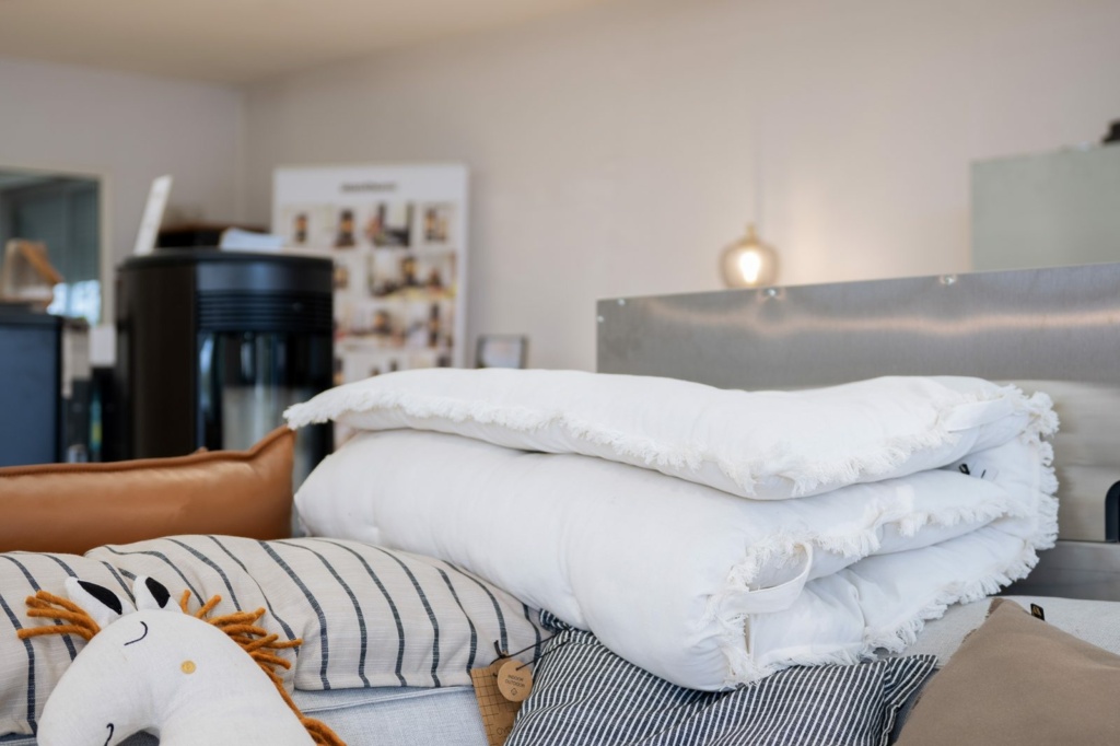 Plaids et coussins empilés dans le showroom Sparte à Toulouse