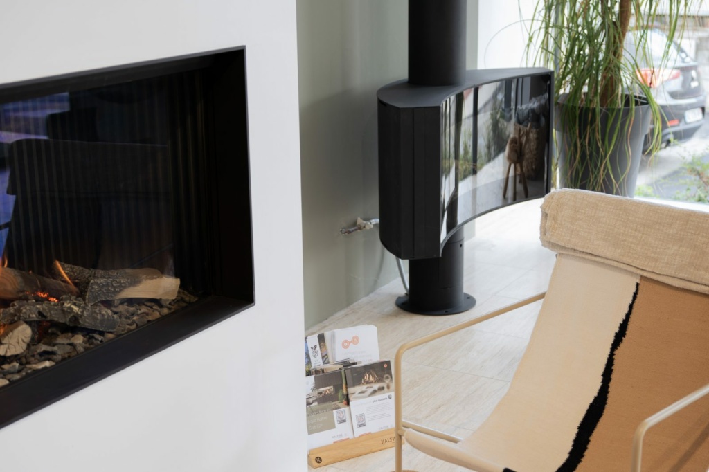 Poêle noir et fauteuil devant la baie du showroom Sparte à Toulouse