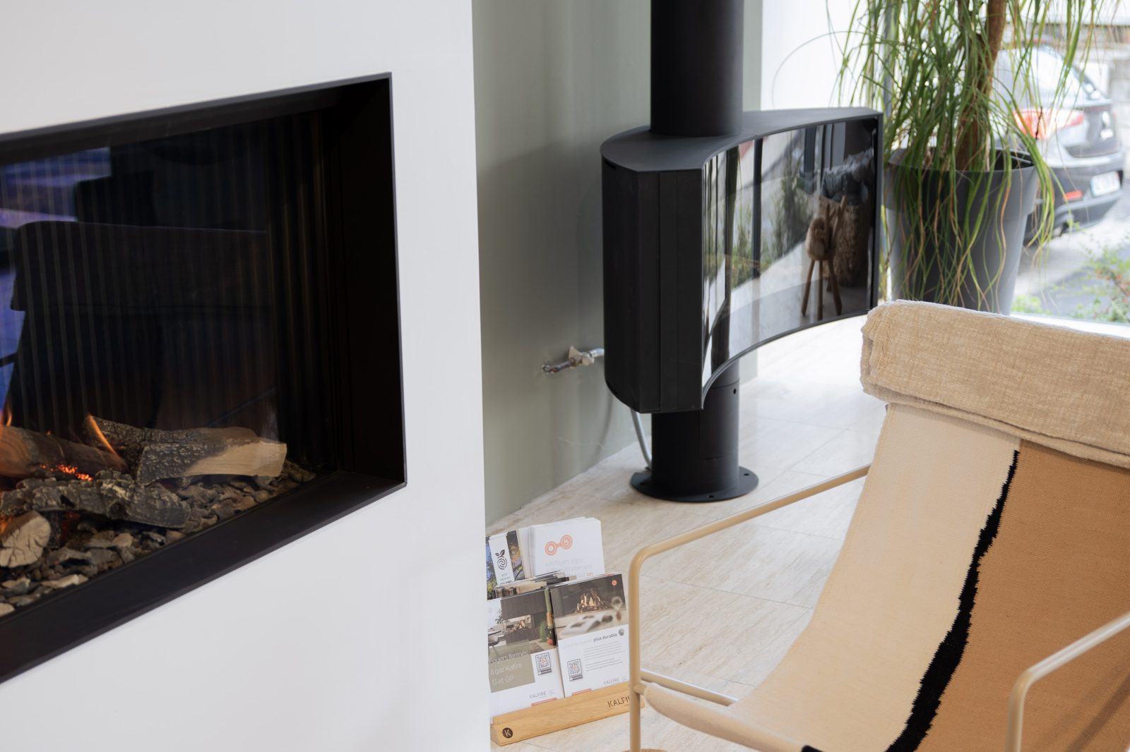 Poêle noir et fauteuil devant la baie du showroom Sparte à Toulouse